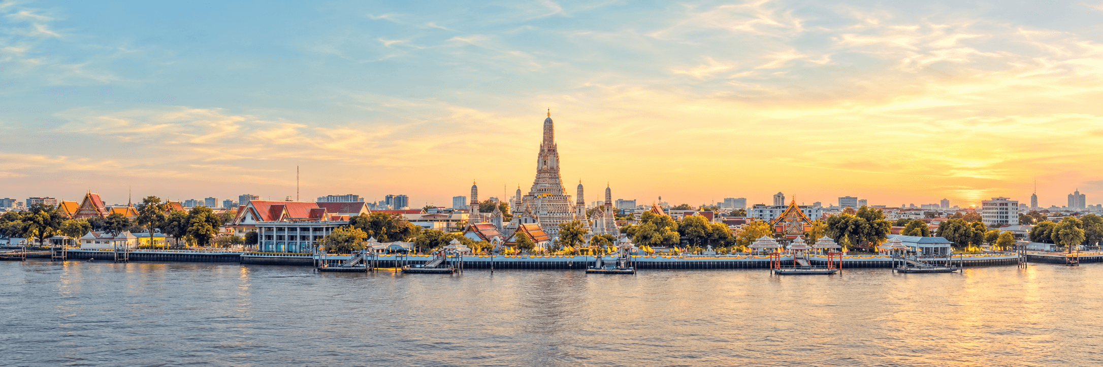 Wat Arun temple across the Chao Phraya River at sunset in Bangkok, Thailand.