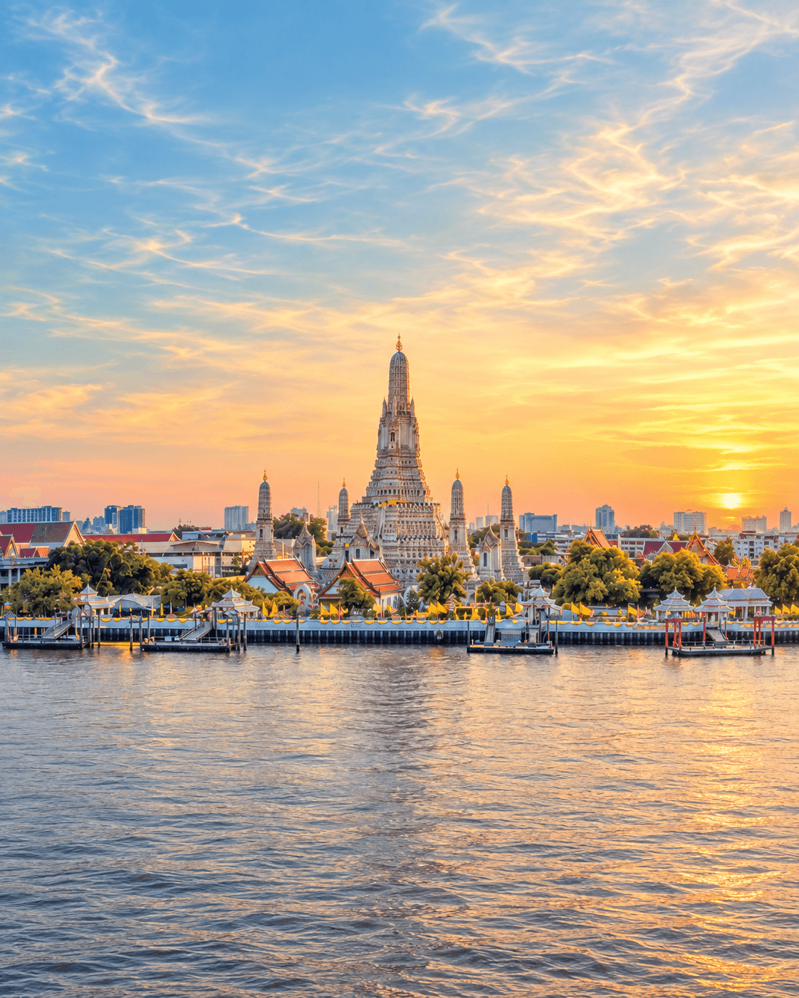 Wat Arun temple across the Chao Phraya River at sunset in Bangkok, Thailand.