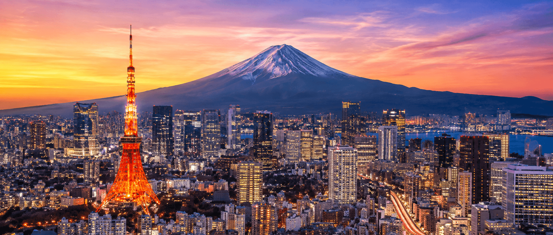 Tokyo skyline at sunset with Tokyo Tower and snow-capped Mount Fuji in the background.